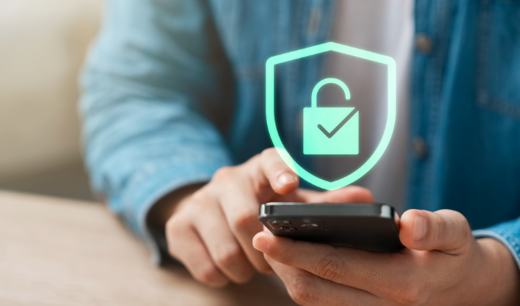 A lock inside a shield hovers over a smartphone in a man's hands.